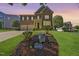 Well-manicured lawn and charming two-story home with a brick facade and two-car garage at 205 Olive Field Dr, Holly Springs, NC 27540