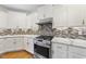 Gourmet kitchen with stainless steel range, stylish backsplash, and marble countertops at 205 Olive Field Dr, Holly Springs, NC 27540