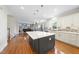 Spacious kitchen with a large center island, hardwood floors, and open to living area at 205 Olive Field Dr, Holly Springs, NC 27540