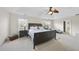 Spacious main bedroom with tray ceiling, large windows, ceiling fan, and neutral carpet at 205 Olive Field Dr, Holly Springs, NC 27540