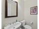 A compact powder room featuring a pedestal sink, framed mirror and a standard toilet at 205 Olive Field Dr, Holly Springs, NC 27540