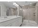 Well-lit bathroom boasts dual sinks, tiled shower with glass door and neutral color palette at 2057 Big Falls Dr, Wendell, NC 27591