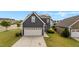 Inviting two-story home featuring a two-car garage, solar panels, and professionally landscaped yard at 2057 Big Falls Dr, Wendell, NC 27591