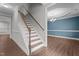 A staircase with a wood handrail leads to a dining room with a chandelier and hardwood floors at 2057 Big Falls Dr, Wendell, NC 27591