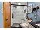 Updated bathroom with a glass-enclosed shower featuring white textured tile and a gray tiled floor at 206 Cottrell Dr, Louisburg, NC 27549