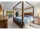Comfortable bedroom with four-poster bed, ceiling fan, and access to outdoor deck through glass door at 206 Cottrell Dr, Louisburg, NC 27549