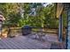 Enjoy outdoor dining on this wooden deck with seating and a grill overlooking the backyard at 206 Cottrell Dr, Louisburg, NC 27549