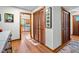 Hallway with hardwood floors and wooden closet doors and kitchen view at 206 Cottrell Dr, Louisburg, NC 27549
