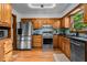Well-equipped kitchen with oak cabinets, stainless steel refrigerator and appliances, and plenty of counter space at 206 Cottrell Dr, Louisburg, NC 27549