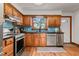 Modern kitchen featuring stainless steel appliances, a window, and wooden cabinets at 206 Cottrell Dr, Louisburg, NC 27549
