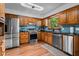 Bright kitchen featuring stainless steel appliances, wooden cabinetry, and a large sink at 206 Cottrell Dr, Louisburg, NC 27549