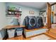 Modern laundry room with front loading washer and dryer, wooden countertop, and shelving for storage at 206 Cottrell Dr, Louisburg, NC 27549