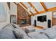 Spacious living room featuring vaulted ceilings, brick fireplace, and a comfortable gray sectional at 206 Cottrell Dr, Louisburg, NC 27549