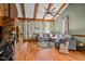 Living room showcasing a brick fireplace, vaulted ceiling, hardwood floors, and a comfortable gray sectional sofa at 206 Cottrell Dr, Louisburg, NC 27549