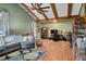 Cozy living room with a vaulted ceiling, exposed beams, and hardwood floors with a comfortable gray sectional sofa at 206 Cottrell Dr, Louisburg, NC 27549