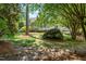 Backyard view of property showing lush green lawn and trees surrounding the home at 206 Glebe Way, Cary, NC 27519