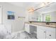 Bathroom featuring dual sinks with granite countertops, a large mirror, and stylish tile flooring at 206 Glebe Way, Cary, NC 27519