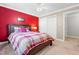 Bedroom featuring a red accent wall, bed, ceiling fan, and access to adjacent rooms at 206 Glebe Way, Cary, NC 27519