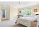 Well-lit bedroom with a bed, ceiling fan, window views, and access to an adjacent room at 206 Glebe Way, Cary, NC 27519