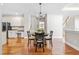 Open dining area with hardwood floors and a view of the kitchen and staircase at 206 Glebe Way, Cary, NC 27519