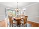 Charming dining room featuring wood floors, chandelier, window seat, and wood trim at 206 Glebe Way, Cary, NC 27519