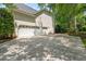 Wide driveway leads to three-car garage with well manicured landscaping at 206 Glebe Way, Cary, NC 27519