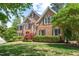 Elegant brick home features manicured landscaping, classic shutters, and a welcoming front yard with mature trees at 206 Glebe Way, Cary, NC 27519