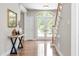 Welcoming foyer featuring a wood staircase, hardwood floors, natural light and an entry table at 206 Glebe Way, Cary, NC 27519
