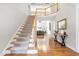Inviting foyer with staircase, hardwood floors, soaring ceilings and views into the living room at 206 Glebe Way, Cary, NC 27519