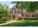 Charming brick two-story home with manicured lawn, arched entry, black shutters, and mature landscaping at 206 Glebe Way, Cary, NC 27519