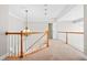 Upstairs hallway has wood railing and a light fixture hanging from the ceiling at 206 Glebe Way, Cary, NC 27519