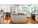 Spacious kitchen with white cabinets, granite counters, and an island cooktop at 206 Glebe Way, Cary, NC 27519