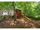 Shaded play area in backyard has wood playhouse with slide and swings at 206 Glebe Way, Cary, NC 27519