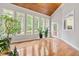 Bright sunroom boasts wood ceiling, hardwood floors, and many windows for natural light and backyard view at 206 Glebe Way, Cary, NC 27519
