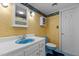Retro bathroom with blue fixtures, unique yellow wallpaper, and vintage-inspired design at 2113 Port Royal Rd, Raleigh, NC 27609