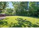 Backyard with lush green grass and trees at 2210 Milburnie Rd, Raleigh, NC 27610