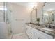 Bright bathroom featuring double vanity, granite countertop, framed mirror and glass shower with marble tile at 2210 Milburnie Rd, Raleigh, NC 27610