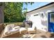 Cozy outdoor deck features wicker seating, throw pillows, and a charming blue door at 2210 Milburnie Rd, Raleigh, NC 27610