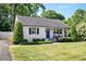 Charming single-story home featuring a landscaped yard, a blue front door, and classic black shutters at 2210 Milburnie Rd, Raleigh, NC 27610
