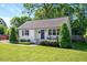 Inviting single-Gathering home with lush front lawn, neatly trimmed shrubs and a vibrant blue front door at 2210 Milburnie Rd, Raleigh, NC 27610