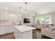 Open-concept kitchen and living room featuring white cabinets, an island, and hardwood floors at 2210 Milburnie Rd, Raleigh, NC 27610