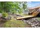 A tranquil backyard with a wooden bridge, rock design, and comfortable seating area at 2301 Bolingbrook Ln, Raleigh, NC 27613