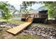 Expansive backyard with a deck, wooden bridge over a rock feature, and well-maintained landscaping at 2301 Bolingbrook Ln, Raleigh, NC 27613