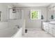 Bright bathroom showcasing the tub, shower, marble floors, and window at 2301 Bolingbrook Ln, Raleigh, NC 27613