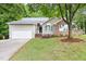 Single-Gathering home with attached garage, manicured lawn and mature shade tree at 2301 Bolingbrook Ln, Raleigh, NC 27613