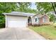 Single-Gathering home with attached garage and concrete driveway and partially shaded by mature trees at 2301 Bolingbrook Ln, Raleigh, NC 27613