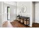 Welcoming foyer with stylish console table, round mirror, wood floors, and natural light streaming in from the doorway at 2301 Bolingbrook Ln, Raleigh, NC 27613