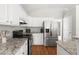 Modern kitchen with stainless steel refrigerator, granite countertops, and abundant white cabinetry at 2301 Bolingbrook Ln, Raleigh, NC 27613