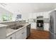 Modern kitchen with stainless steel appliances, granite counters, white cabinets, and seamless flow into adjacent living area at 2301 Bolingbrook Ln, Raleigh, NC 27613
