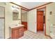 Cozy bathroom featuring a wood vanity with a marble countertop, tiled floors, and access to other rooms at 251 Charles Riddle Rd, Sanford, NC 27330